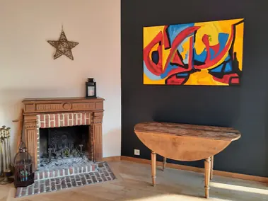 Peinture intérieure mur gris anthracite et beige, cheminée en bois et parquet.