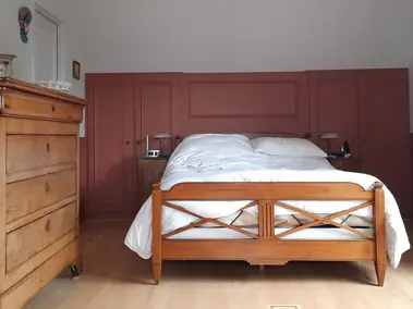 Peinture intérieure chambre avec panneaux muraux rouge brique, murs gris et parquet.