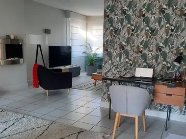 Salon avec papier peint tropical toucans et murs peints gris clair sol carrelé
