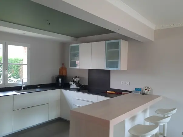 Peinture cuisine murs gris clair et plafond vert sauge avec moulure de plafond blanche.